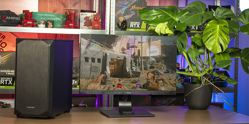 Gaming desktop en monitor op een bureau met computer onderdelen op achtergrond