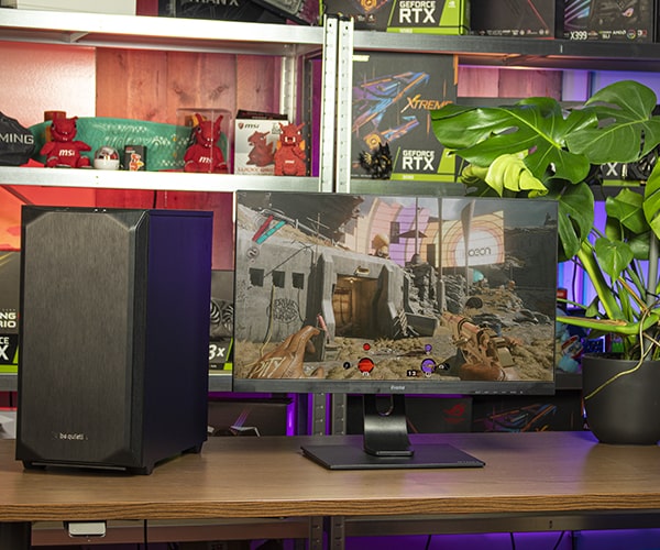 Gaming desktop en monitor op een bureau met computer onderdelen op achtergrond